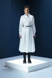 Saia midi de tricoline com cinto de couro destacável. Cintura alta, pregas estruturadas e toque leve. Elegância prática para o dia a dia.