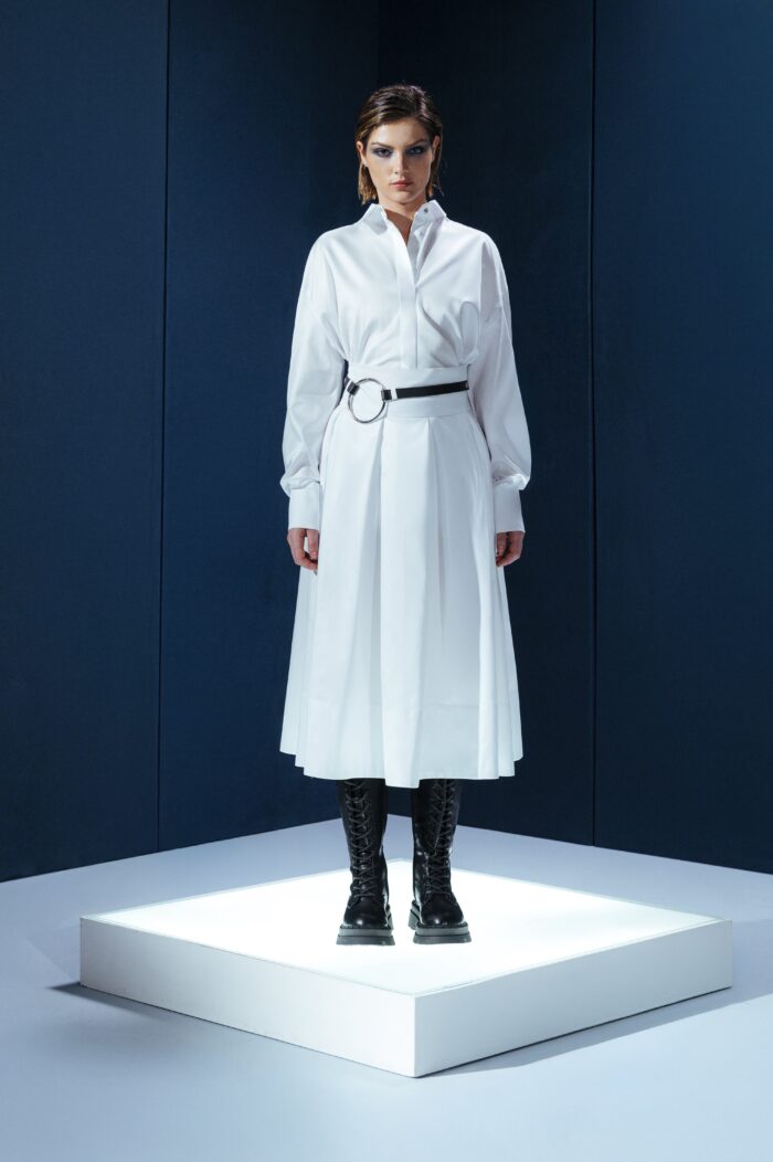 Saia midi de tricoline com cinto de couro destacável. Cintura alta, pregas estruturadas e toque leve. Elegância prática para o dia a dia.