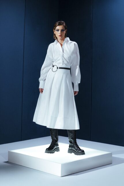 Saia midi de tricoline com cinto de couro destacável. Cintura alta, pregas estruturadas e toque leve. Elegância prática para o dia a dia.