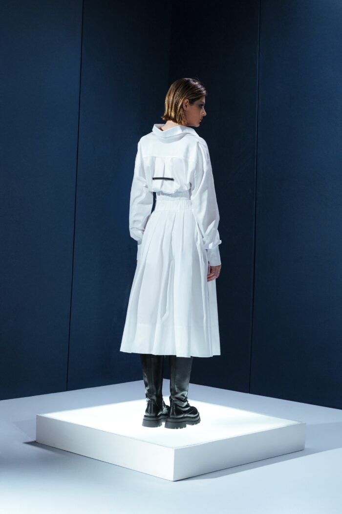 Saia midi de tricoline com cinto de couro destacável. Cintura alta, pregas estruturadas e toque leve. Elegância prática para o dia a dia.