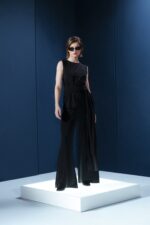 Blusa sem mangas em jersey preto com amarração na cintura. Sofisticação fluida com toque macio e caimento impecável
