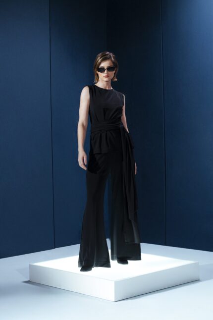 Blusa sem mangas em jersey preto com amarração na cintura. Sofisticação fluida com toque macio e caimento impecável