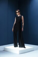 Blusa sem mangas em jersey preto com amarração na cintura. Sofisticação fluida com toque macio e caimento impecável