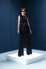 Blusa em jersey preto com ombreiras embutidas. Estrutura leve e caimento impecável para um visual refinado e contemporâneo.