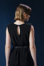 Blusa em jersey preto com ombreiras embutidas. Estrutura leve e caimento impecável para um visual refinado e contemporâneo.