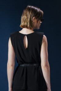 Blusa em jersey preto com ombreiras embutidas. Estrutura leve e caimento impecável para um visual refinado e contemporâneo.