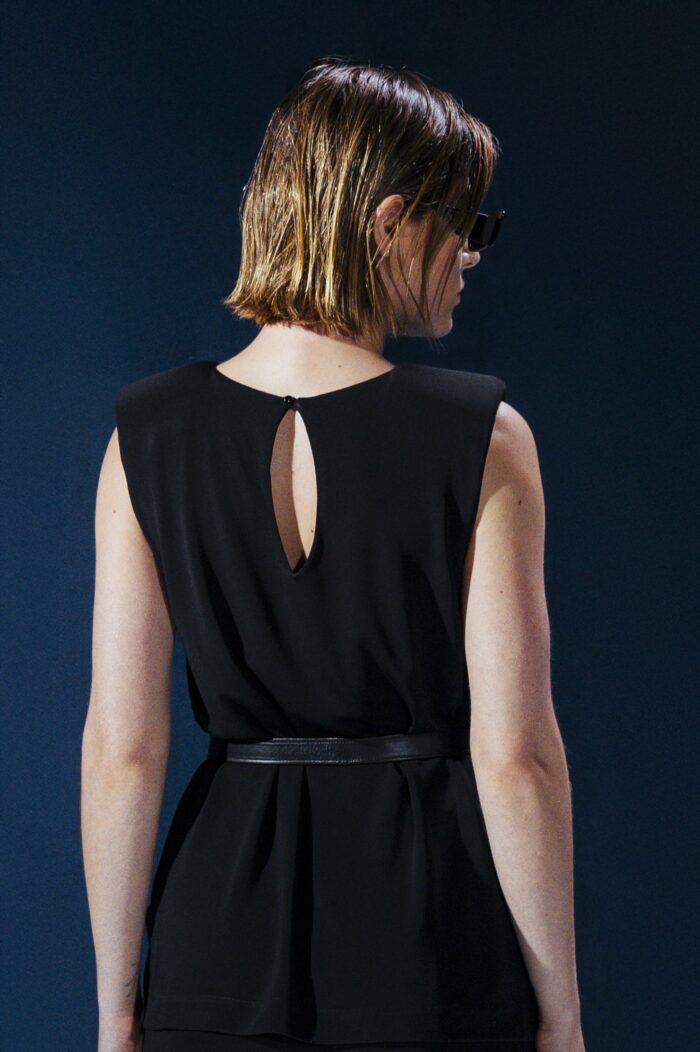 Blusa em jersey preto com ombreiras embutidas. Estrutura leve e caimento impecável para um visual refinado e contemporâneo.