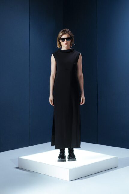 Vestido longo em jersey preto com capuz e fendas laterais. Silhueta reta com toque urbano e sofisticado. Conforto e presença em um só gesto