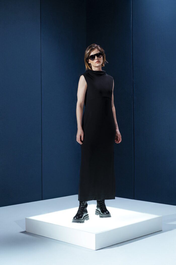 Vestido longo em jersey preto com capuz e fendas laterais. Silhueta reta com toque urbano e sofisticado. Conforto e presença em um só gesto