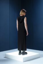 Vestido longo em jersey preto com capuz e fendas laterais. Silhueta reta com toque urbano e sofisticado. Conforto e presença em um só gesto