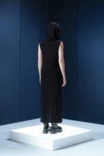 Vestido longo em jersey preto com capuz e fendas laterais. Silhueta reta com toque urbano e sofisticado. Conforto e presença em um só gesto