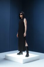 Vestido longo em jersey preto com capuz e fendas laterais. Silhueta reta com toque urbano e sofisticado. Conforto e presença em um só gesto