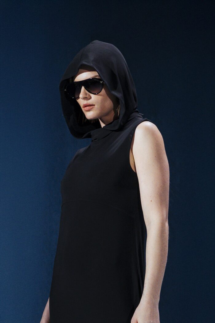 Vestido longo em jersey preto com capuz e fendas laterais. Silhueta reta com toque urbano e sofisticado. Conforto e presença em um só gesto