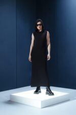 Vestido longo em jersey preto com capuz e fendas laterais. Silhueta reta com toque urbano e sofisticado. Conforto e presença em um só gesto