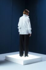 Camisa branca de tricoline com recorte estratégico no cotovelo. Silhueta reta com refinamento contemporâneo e caimento sofisticado.