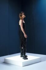 Vestido preto em lã fria com alças ajustáveis nas costas e argolas metálicas laterais que permitem franzir a peça. Design versátil e sofisticado.