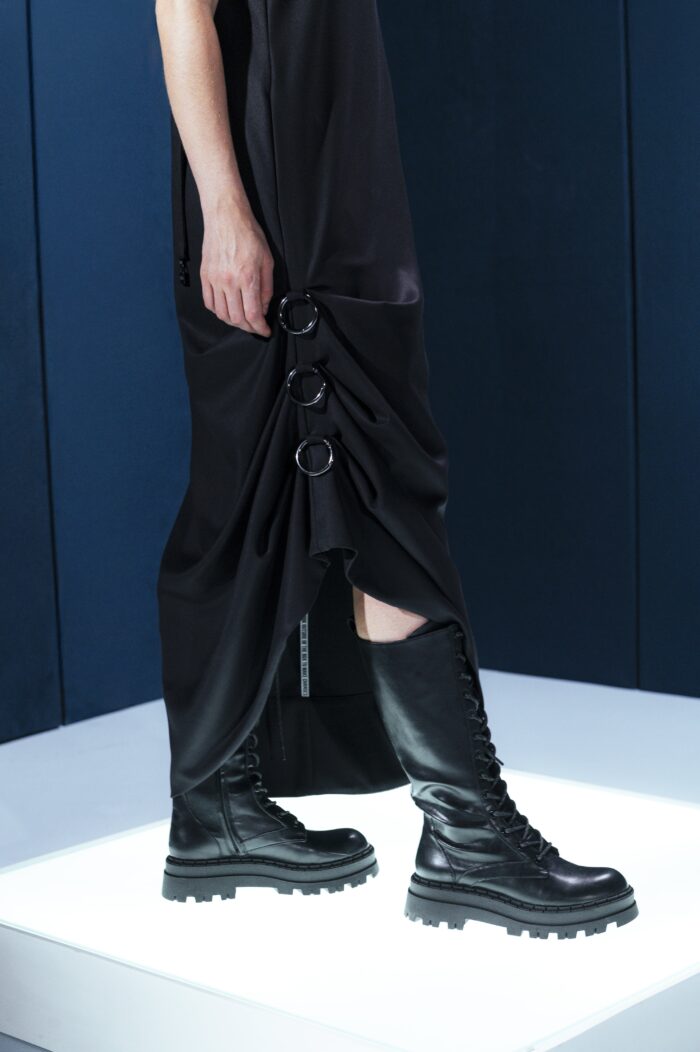 Vestido preto em lã fria com alças ajustáveis nas costas e argolas metálicas laterais que permitem franzir a peça. Design versátil e sofisticado.