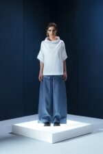 Camisa de tricoline com gola ampla e recortes diagonais. Uma peça contemporânea com inspiração arquitetônica e caimento estruturado.