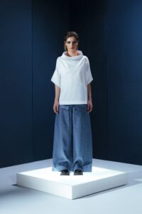 Camisa de tricoline com gola ampla e recortes diagonais. Uma peça contemporânea com inspiração arquitetônica e caimento estruturado.