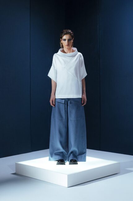 Camisa de tricoline com gola ampla e recortes diagonais. Uma peça contemporânea com inspiração arquitetônica e caimento estruturado.