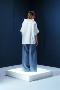 Camisa de tricoline com gola ampla e recortes diagonais. Uma peça contemporânea com inspiração arquitetônica e caimento estruturado.