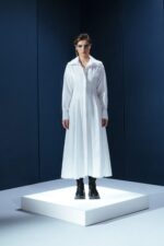 Vestido longo de tricoline com mangas compridas e modelagem acinturada. Sofisticação atemporal com toque contemporâneo.