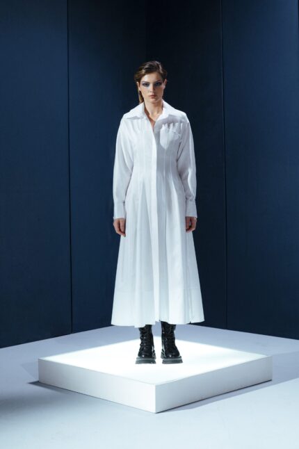 Vestido longo de tricoline com mangas compridas e modelagem acinturada. Sofisticação atemporal com toque contemporâneo.