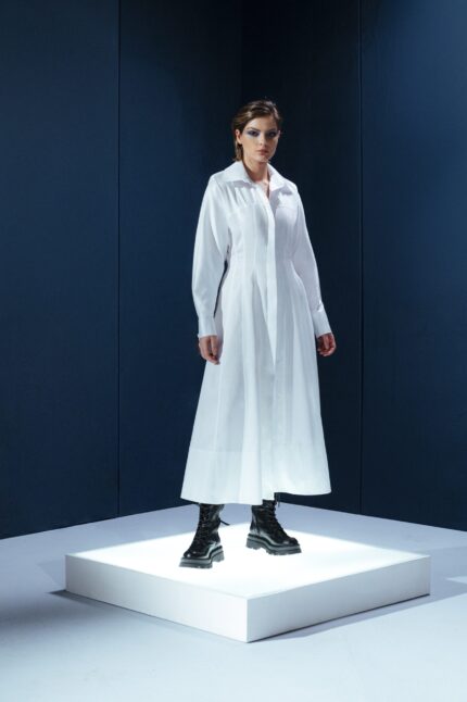 Vestido longo de tricoline com mangas compridas e modelagem acinturada. Sofisticação atemporal com toque contemporâneo.