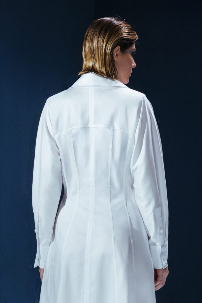 Vestido longo de tricoline com mangas compridas e modelagem acinturada. Sofisticação atemporal com toque contemporâneo.
