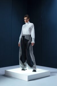 Camisa em tricoline branca com argola de metal no punho. Silhueta clássica com detalhe contemporâneo e toque de alfaiataria minimalista.