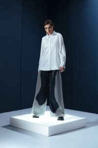 Camisa em tricoline branca com argola de metal no punho. Silhueta clássica com detalhe contemporâneo e toque de alfaiataria minimalista.