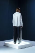 Camisa em tricoline branca com argola de metal no punho. Silhueta clássica com detalhe contemporâneo e toque de alfaiataria minimalista.