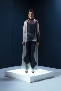 Camisa oversized em organza de seda com botões forrados e segunda pele de tecido de acetato. Transparência sofisticada com conforto e presença.