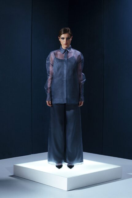 Camisa oversized em organza de seda com botões forrados e segunda pele de tecido de acetato. Transparência sofisticada com conforto e presença.