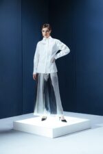 Camisa de tricoline com gola turca e pregas frontais. Silhueta limpa com detalhes arquitetônicos que revelam sofisticação contemporânea.