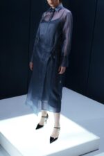 Chemise de organza com panneaux ajustável e fivelas metálicas. Peça leve com estrutura sofisticada e segunda pele em acetato.