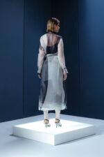 Chemise de organza com panneaux ajustável e fivelas metálicas. Peça leve com estrutura sofisticada e segunda pele em acetato.