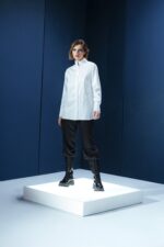 Camisa branca em tricoline com gola alta e abotoamento embutido. Estrutura limpa e elegante com caimento preciso e sofisticação minimalista.