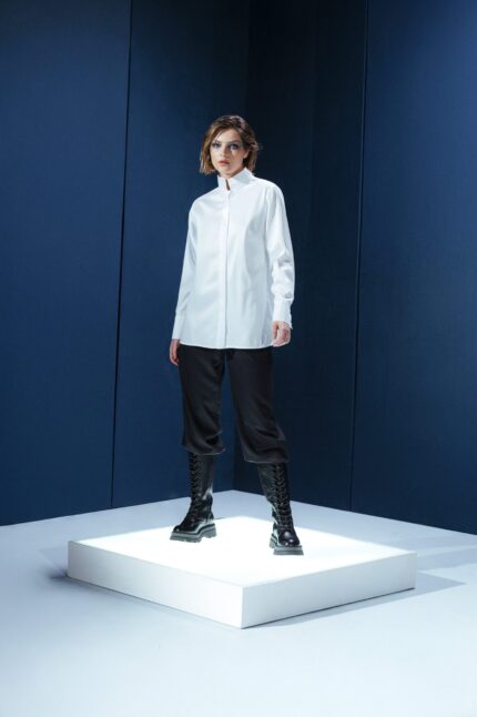 Camisa branca em tricoline com gola alta e abotoamento embutido. Estrutura limpa e elegante com caimento preciso e sofisticação minimalista.