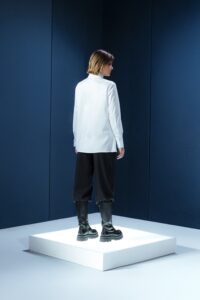 Camisa branca em tricoline com gola alta e abotoamento embutido. Estrutura limpa e elegante com caimento preciso e sofisticação minimalista.