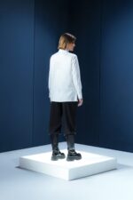 Camisa branca em tricoline com gola alta e abotoamento embutido. Estrutura limpa e elegante com caimento preciso e sofisticação minimalista.