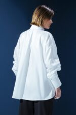 Camisa branca em tricoline com bolsos frontais e amarração interna para franzir a manga. Clássica com um toque moderno e elegante.