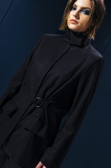 Blazer em lã fria com gola alta e ajuste na cintura com argola metálica. Ideal para invernos leves. Elegância e proteção no mesmo gesto.