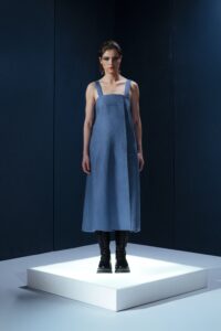 Vestido midi em linho com pregas frontais, alças largas ajustáveis e detalhe estruturado nas costas. Minimalismo com personalidade.