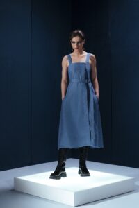 Vestido midi em linho com pregas frontais, alças largas ajustáveis e detalhe estruturado nas costas. Minimalismo com personalidade.