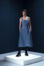 Vestido midi em linho com pregas frontais, alças largas ajustáveis e detalhe estruturado nas costas. Minimalismo com personalidade.