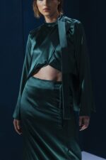 Blusa de seda com gola laço e modelagem versátil. Pode ser usada solta ou com amarração interna nas costas, unindo sofisticação e originalidade.